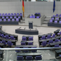 Plenarsaal des Deutschen Bundestages im Sonnenlicht mit der Deutschland und Europaflagge