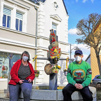 Kerstin Zinnert und Udo Herrmann vor dem geschmückten Osterbrunnen